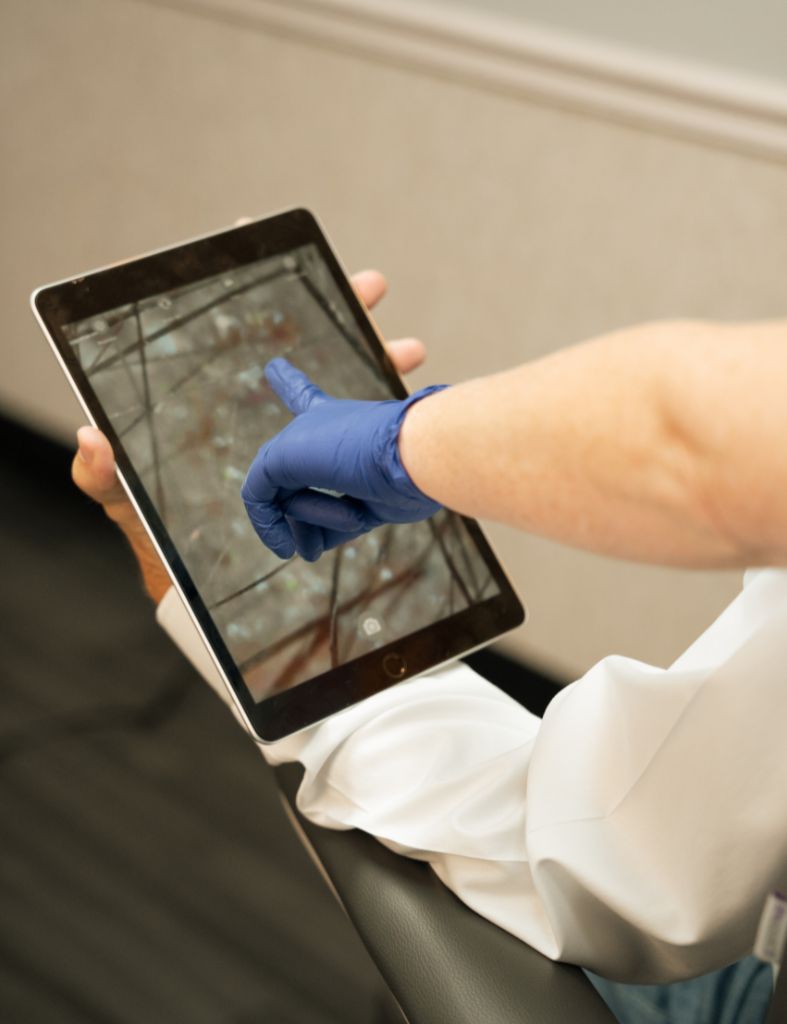 Provider reviewing a magnified scalp evaluation during a hair restoration consultation