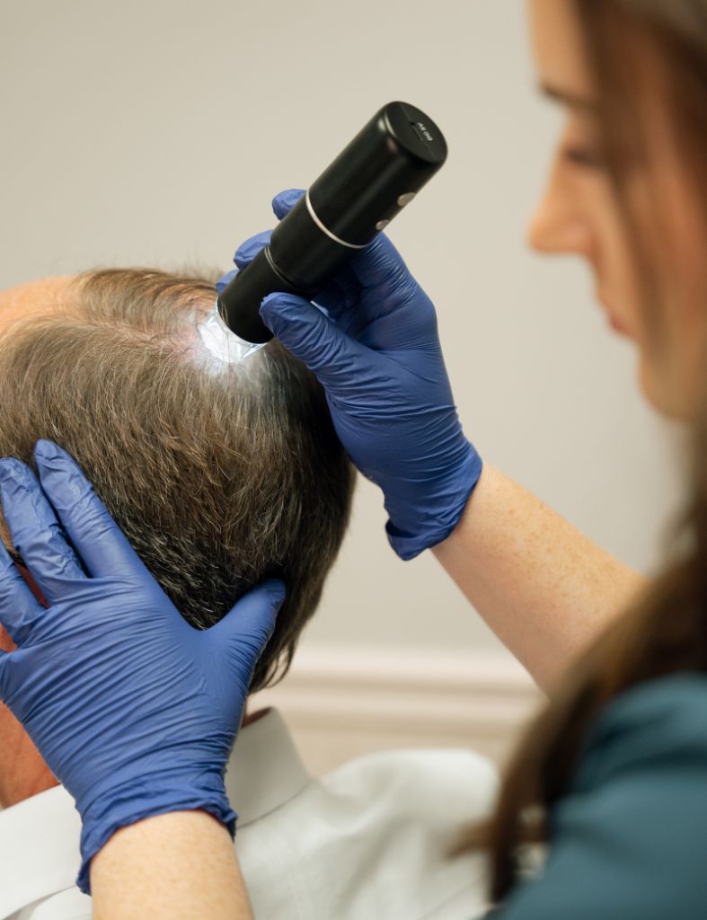 Provider at Tennessee Health & Wellness in Cookeville, TN examining a patient’s scalp and areas of hair thinning